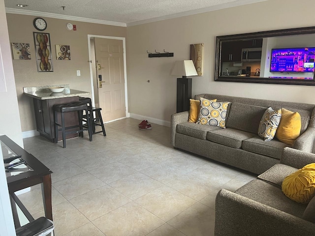 living room with crown molding, a textured ceiling, and light tile patterned floors