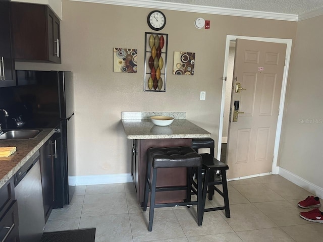 kitchen featuring stainless steel dishwasher, sink, light tile patterned flooring, and crown molding