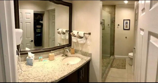 3100 Parkway Blvd Unit 717, Kissimmee, FL 34747 - bathroom with toilet, tile patterned flooring, a stall shower, vanity, and baseboards