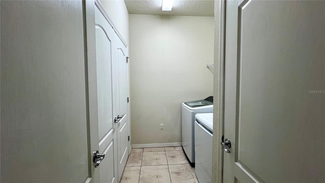 laundry room with independent washer and dryer, a textured ceiling, and light tile patterned floors