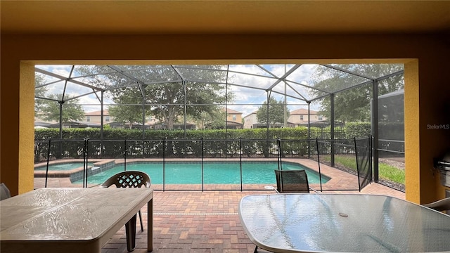 view of pool featuring an in ground hot tub, a patio, and a lanai