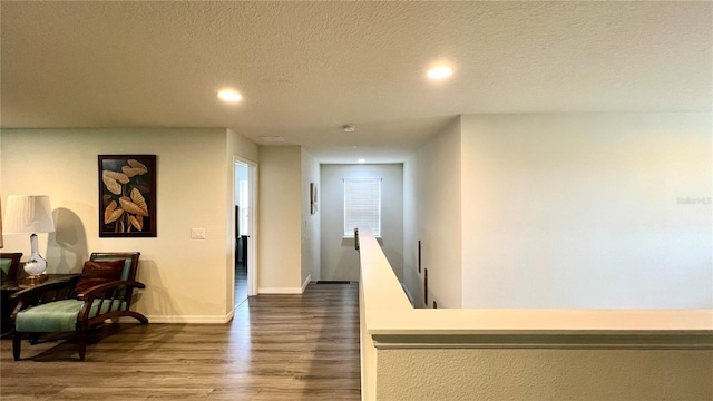 hall featuring a textured ceiling and dark hardwood / wood-style flooring