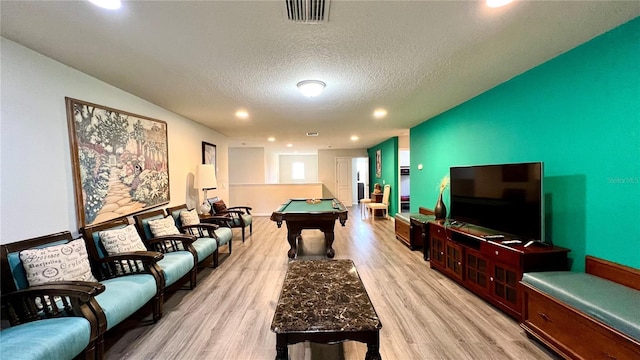 recreation room featuring light hardwood / wood-style flooring, a textured ceiling, and billiards