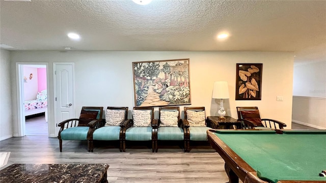 recreation room with wood-type flooring, a textured ceiling, and billiards