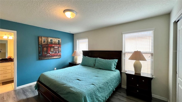 bedroom featuring a textured ceiling, dark hardwood / wood-style flooring, and ensuite bath