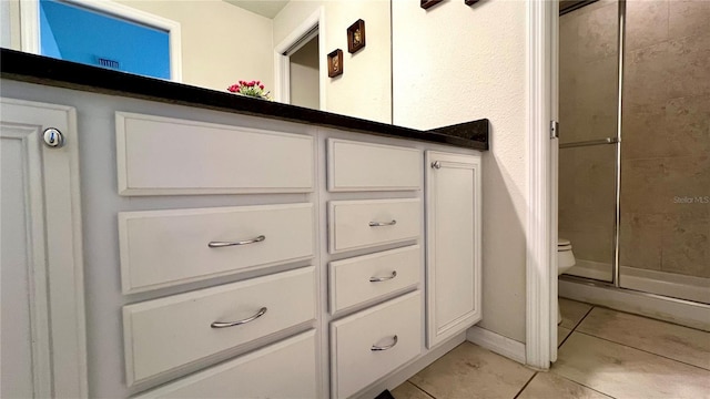 bathroom featuring toilet, tile patterned floors, and a shower with door