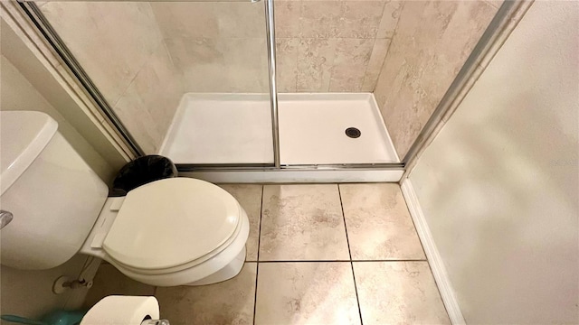 bathroom featuring tiled shower, tile patterned floors, and toilet