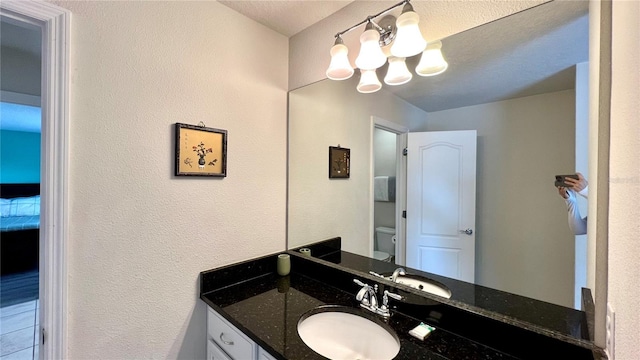 bathroom featuring vanity, a chandelier, and toilet