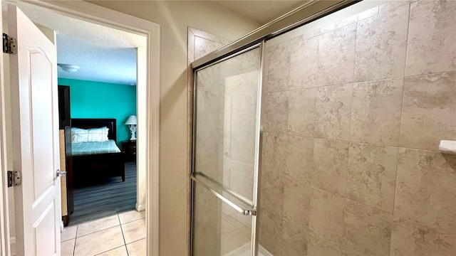 bathroom featuring a shower with shower door and a textured ceiling