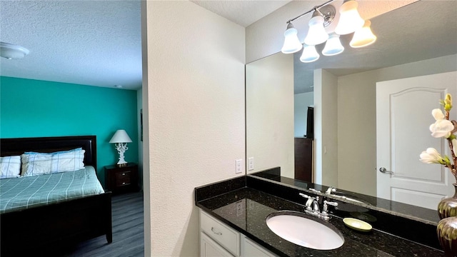 bathroom featuring vanity, wood-type flooring, a textured ceiling, and a notable chandelier