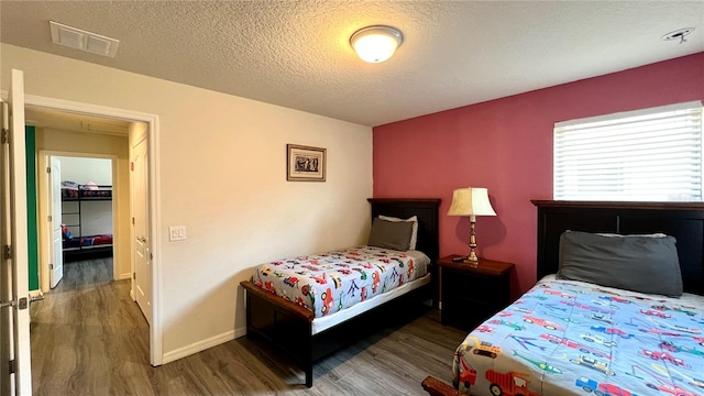 bedroom featuring dark wood-type flooring and a textured ceiling