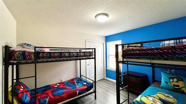 bedroom featuring a closet, a textured ceiling, and hardwood / wood-style flooring