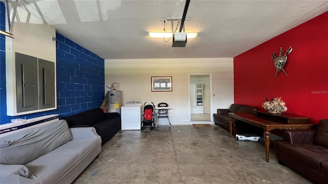 living room with concrete flooring, a textured ceiling, washer / clothes dryer, and water heater