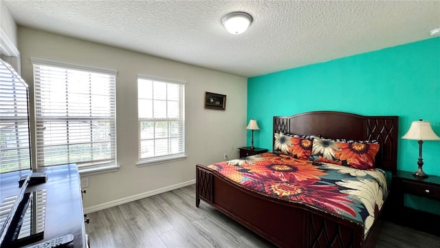 bedroom featuring a textured ceiling and light hardwood / wood-style flooring