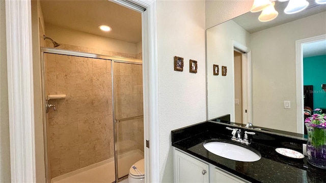 bathroom featuring an enclosed shower, vanity, and toilet