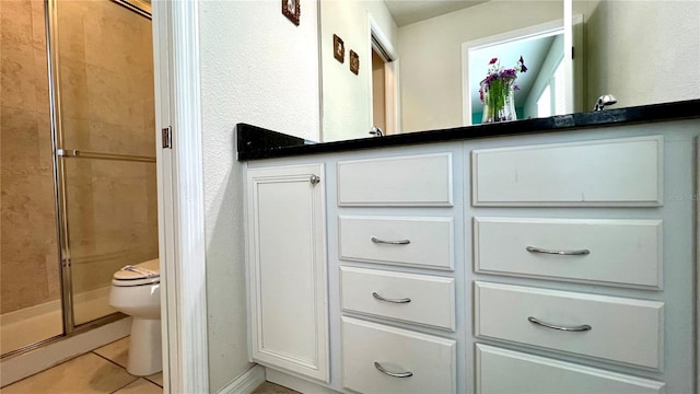 bathroom with toilet, a shower with door, and tile patterned flooring