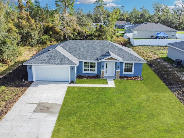 ranch-style house with a garage, a front lawn, and central air condition unit