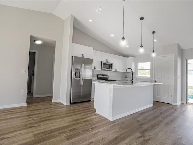 kitchen featuring appliances with stainless steel finishes, white cabinetry, a center island with sink, and dark hardwood / wood-style flooring