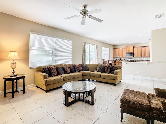 tiled living room featuring ceiling fan and sink