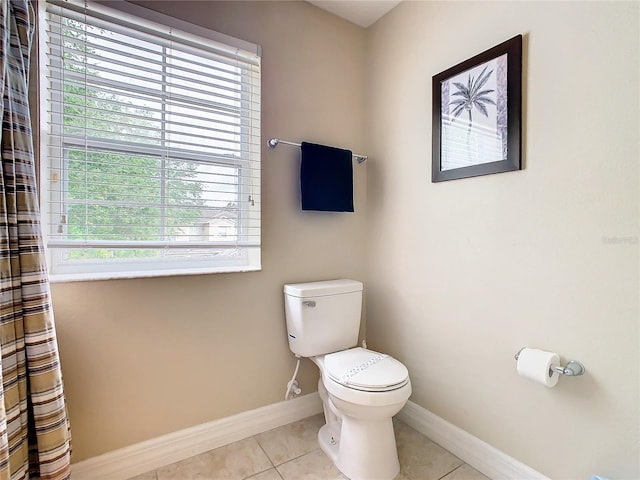 bathroom featuring toilet, tile patterned floors, and a wealth of natural light