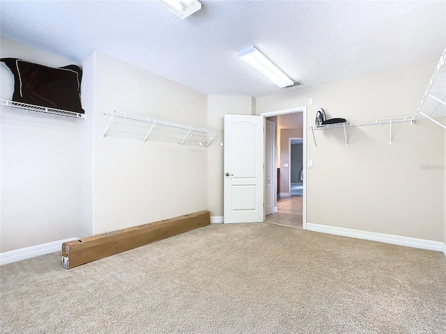 walk in closet with light colored carpet