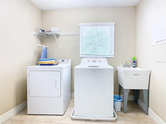 clothes washing area featuring light tile patterned floors and washer and clothes dryer