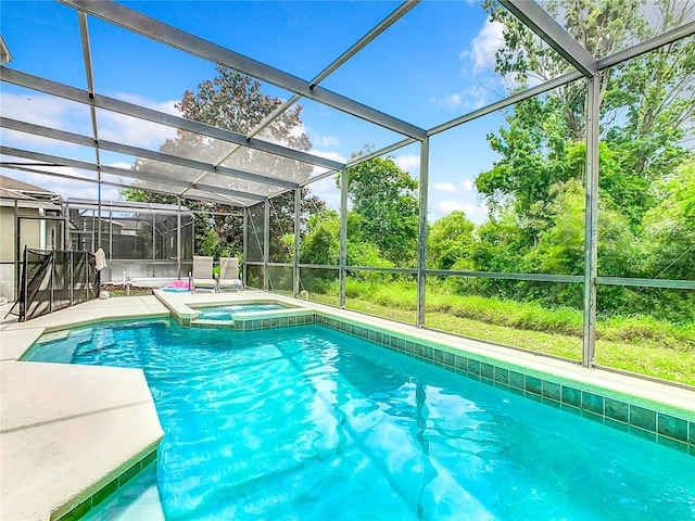 view of swimming pool with a patio, a lanai, and an in ground hot tub