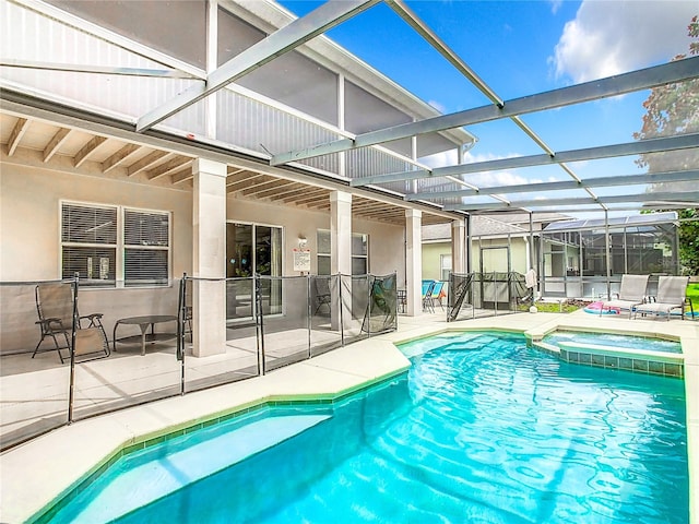 view of swimming pool with an in ground hot tub, a patio area, and glass enclosure