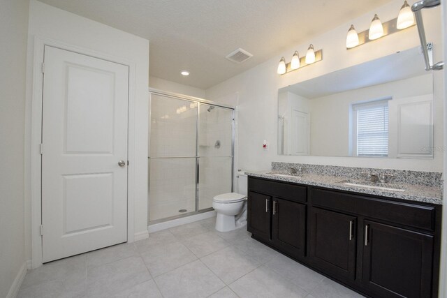 bathroom with vanity, tile patterned flooring, toilet, and walk in shower