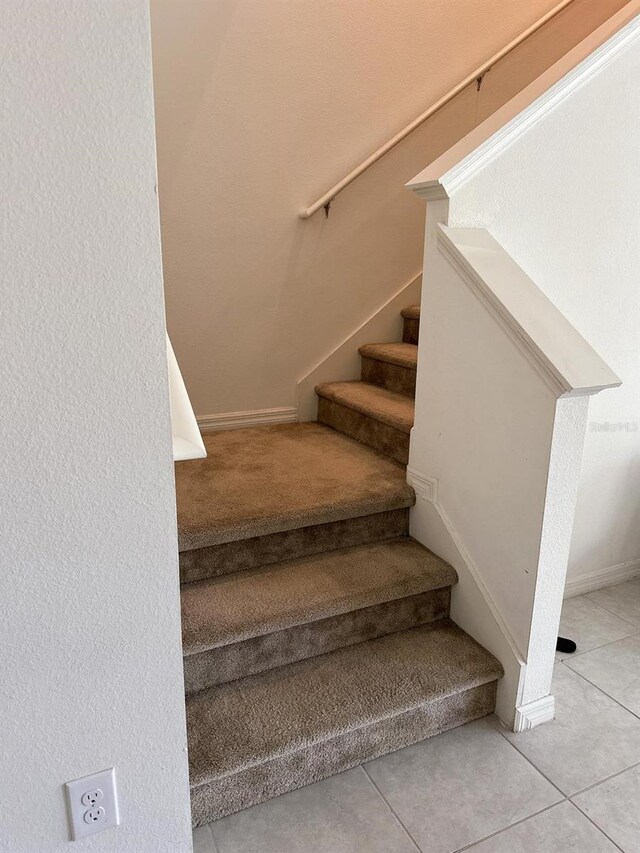 stairs featuring tile patterned floors