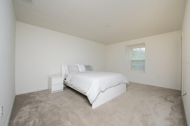 carpeted bedroom featuring a textured ceiling