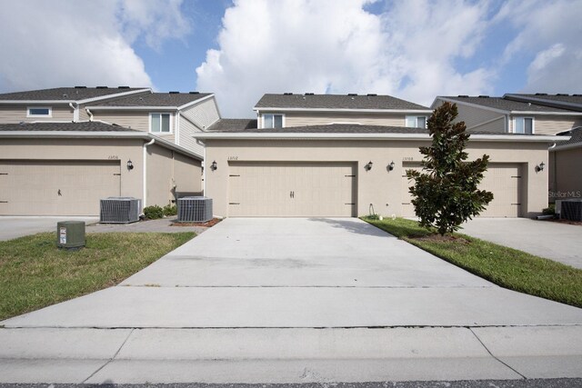 view of front of home with a garage and central air condition unit