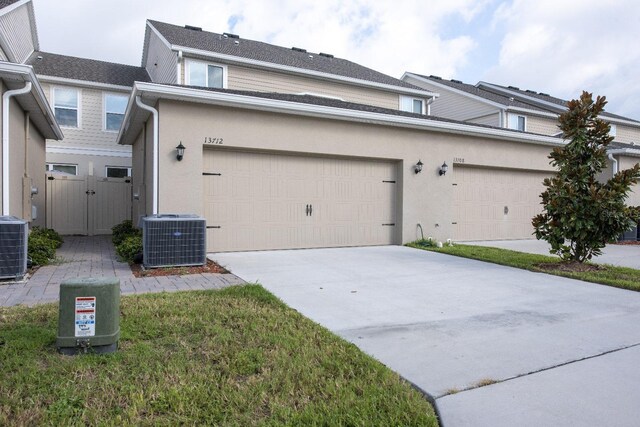 view of side of property with a garage and central air condition unit