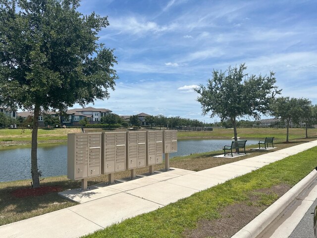 view of property's community with a water view and a mail area