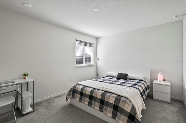 bedroom featuring baseboards, carpet, and a textured ceiling