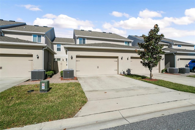 view of front of house with central air condition unit, concrete driveway, and stucco siding