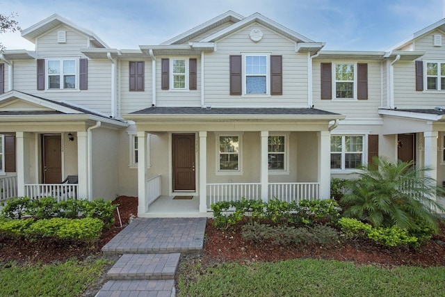 multi unit property featuring a porch and stucco siding