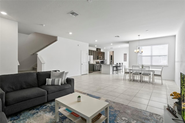 living room with visible vents, recessed lighting, light tile patterned flooring, a chandelier, and stairs