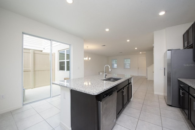 kitchen with an island with sink, light tile patterned floors, appliances with stainless steel finishes, plenty of natural light, and a sink
