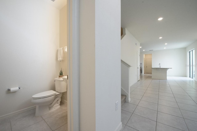 bathroom featuring baseboards, toilet, recessed lighting, tile patterned floors, and a sink