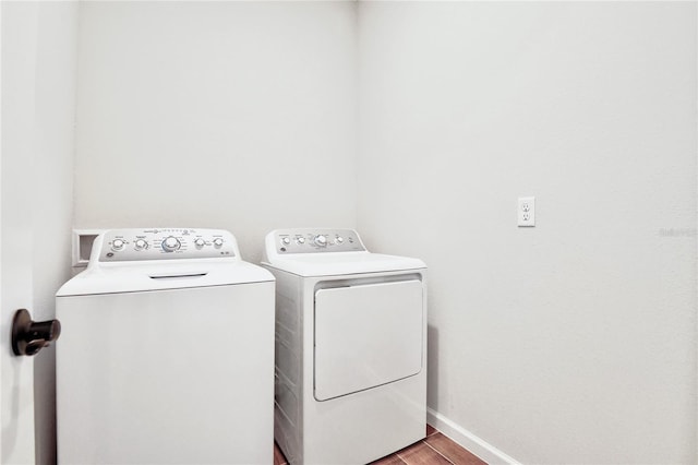 laundry area with washing machine and dryer and light wood-type flooring