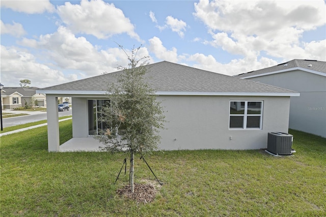 rear view of property featuring a lawn, a patio area, and cooling unit