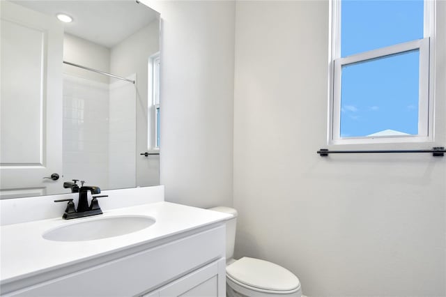 bathroom featuring walk in shower, vanity, and toilet