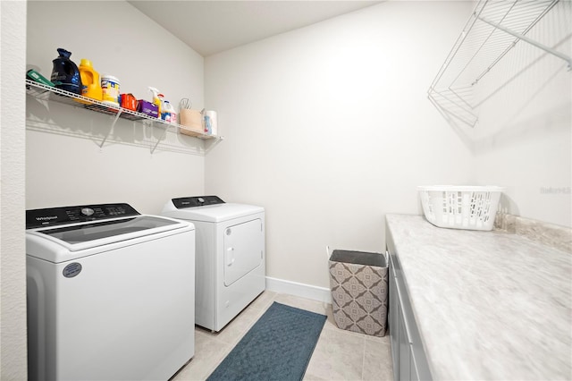 laundry room featuring washer and dryer and light tile flooring