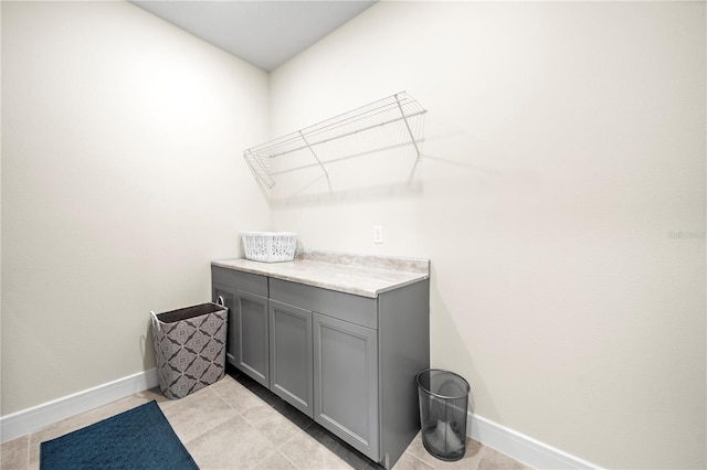 clothes washing area with light tile floors