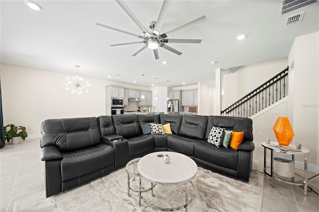 tiled living room with ceiling fan with notable chandelier