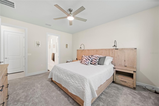 bedroom with light carpet, connected bathroom, and ceiling fan