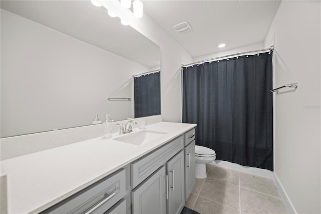 bathroom featuring tile flooring, toilet, and large vanity