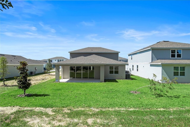 back of property with a yard and a patio area