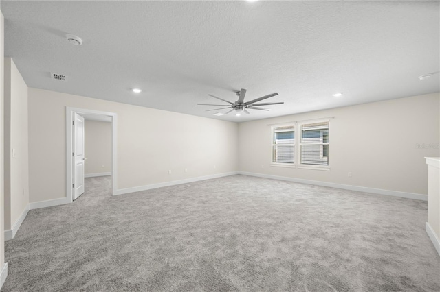 carpeted empty room featuring ceiling fan and a textured ceiling